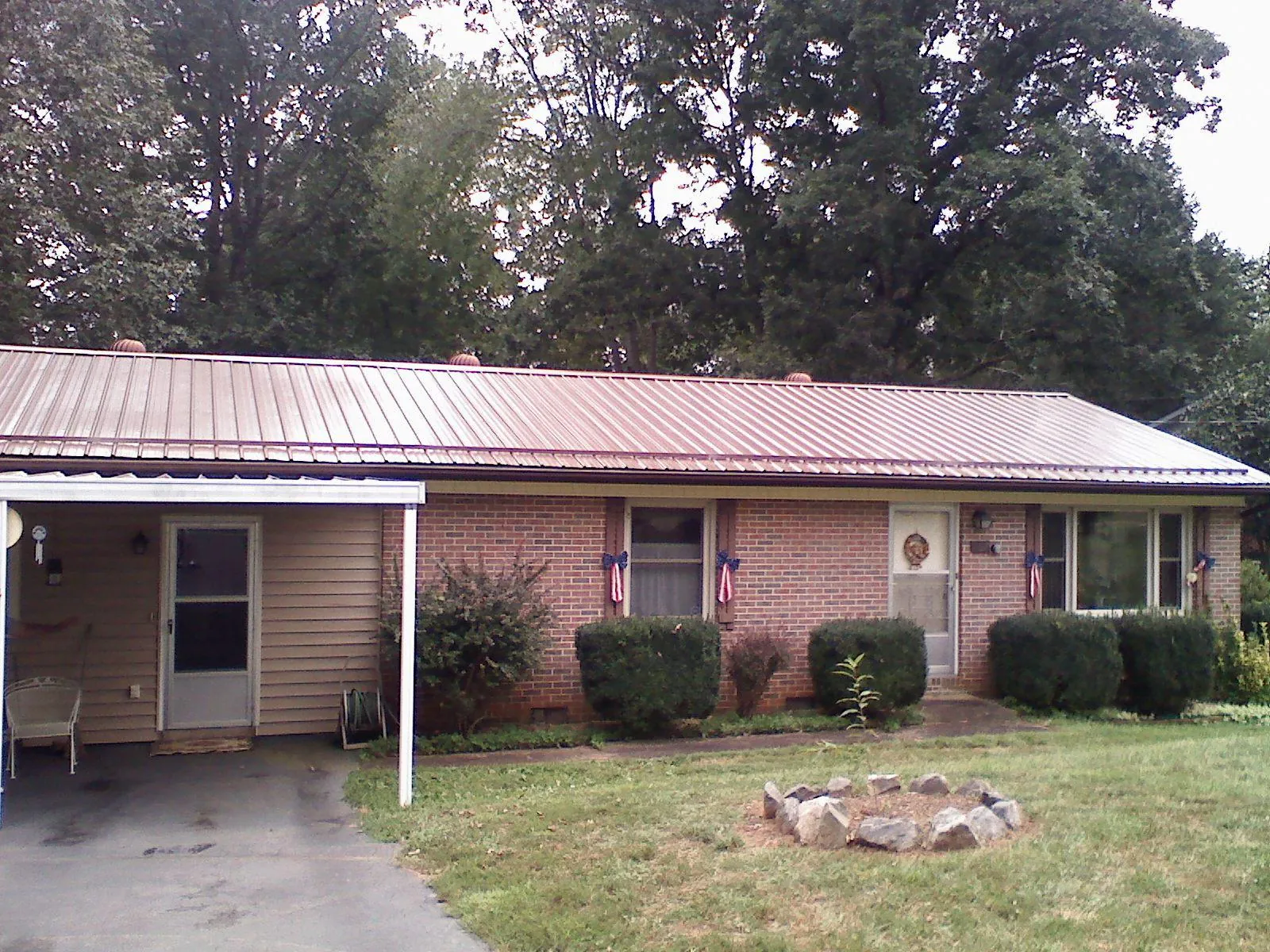 Bronze metal roof and carport on a brick ranch home — Roof Repair work by our crew in Stacyville